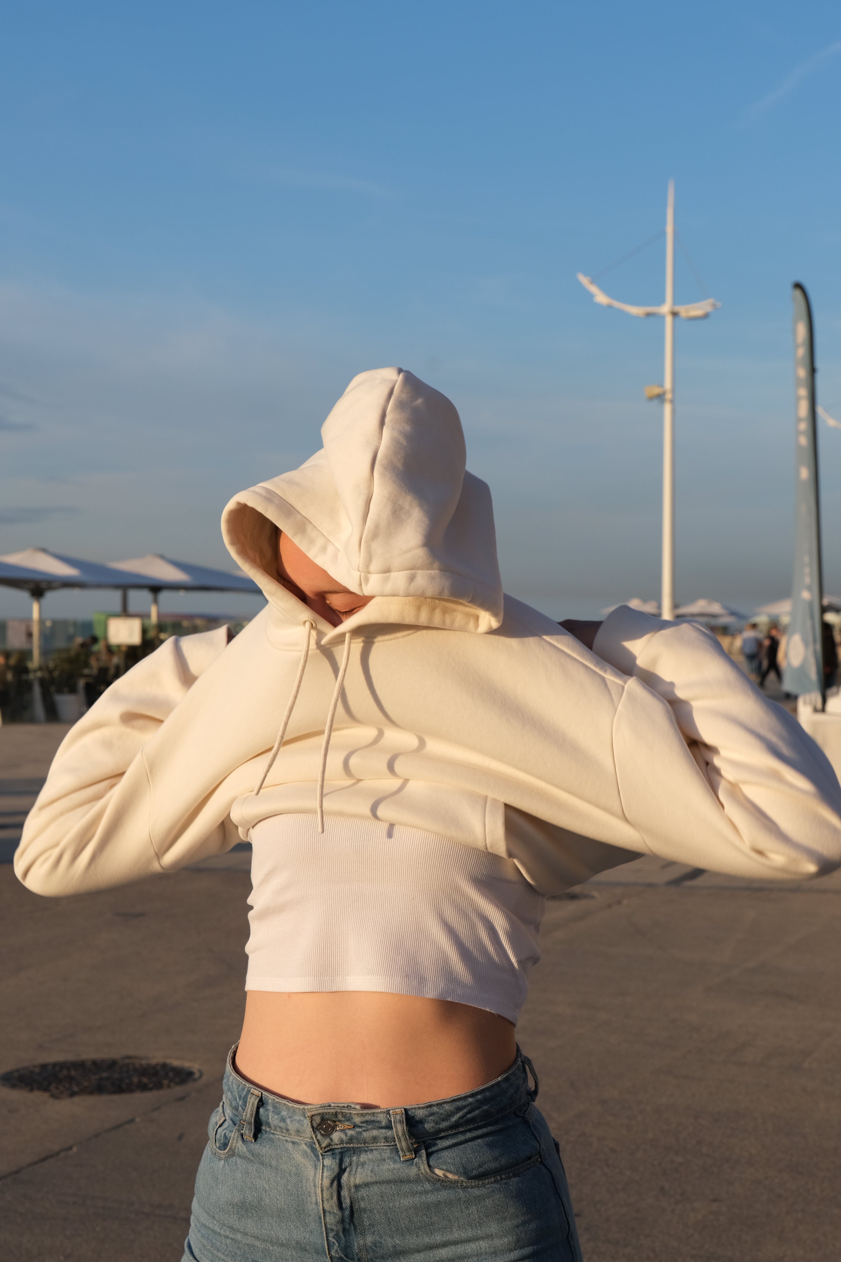 femme qui enfile un hoodie beige